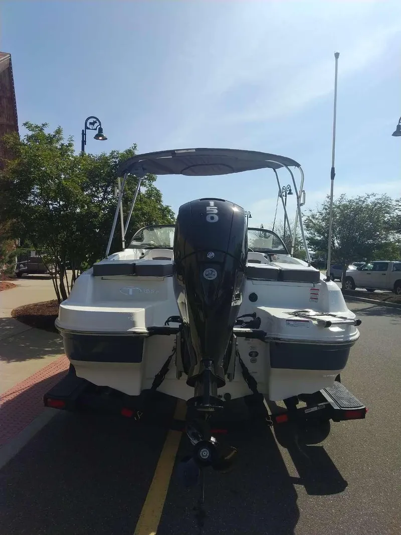 Slide: The Image of 2024 Tahoe 185 S boat with outboard motor, parked on a sunny street. - 2