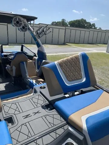Slide: The Image of 2021 Tigé ZX Class 25 ZX boat interior with blue and tan seating. - 17