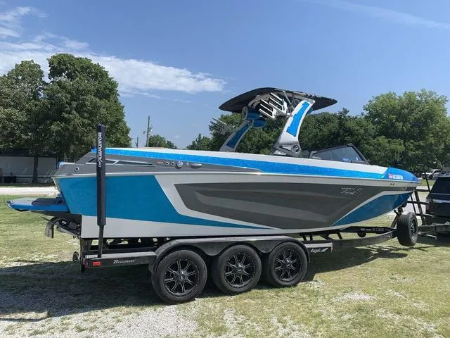 Slide: The Image of 2021 Tigé ZX Class 25 ZX boat on a trailer in a grassy area. - 5