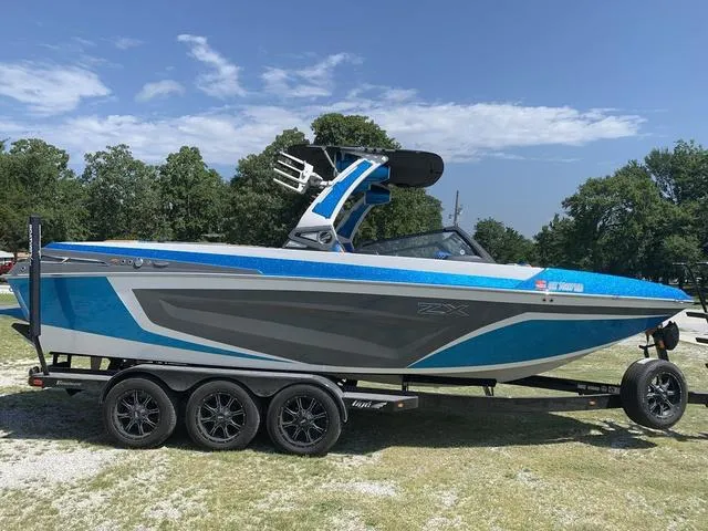Slide: The Image of 2021 Tigé ZX Class 25 ZX boat on a trailer, blue and gray, side view. - 6