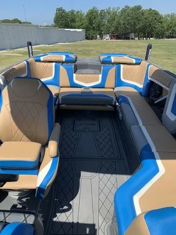Slide: The Image of 2021 Tigé ZX Class 25 ZX boat interior with tan and blue seating. - 8