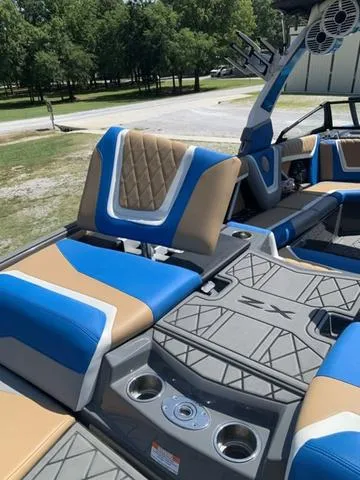 Slide: The Image of 2021 Tigé ZX Class 25 ZX boat interior with blue and tan seating. - 9