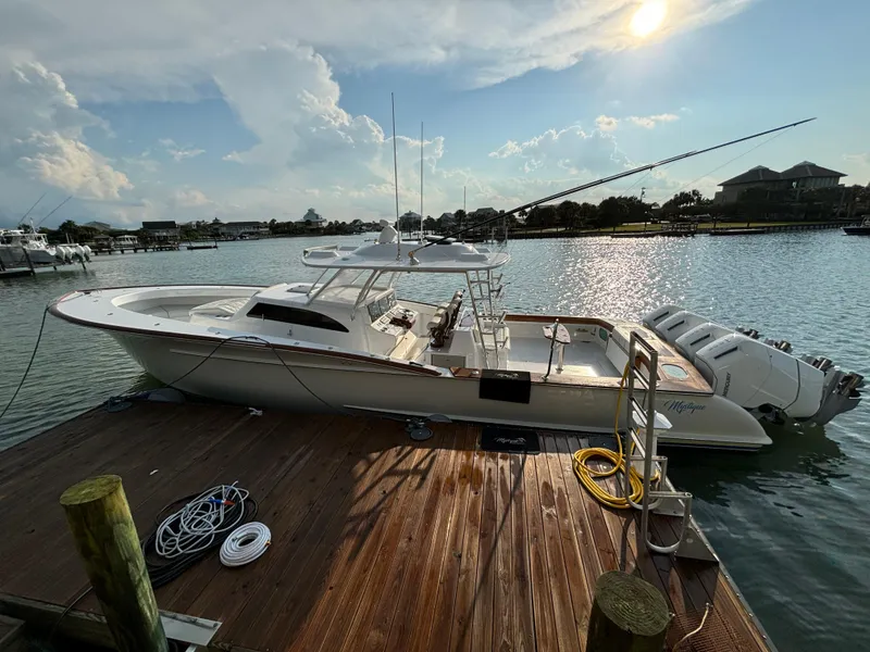 Slide: The Image of 2025 Mystique Boatworks M48 Custom Carolina docked at sunset, featuring sleek design and powerful engines. - 10