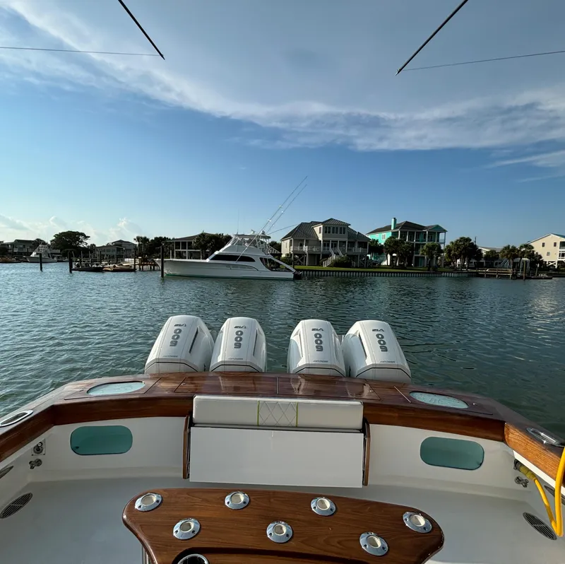 Slide: The Image of 2025 Mystique Boatworks M48 Custom Carolina on serene waterfront with luxury homes. - 13