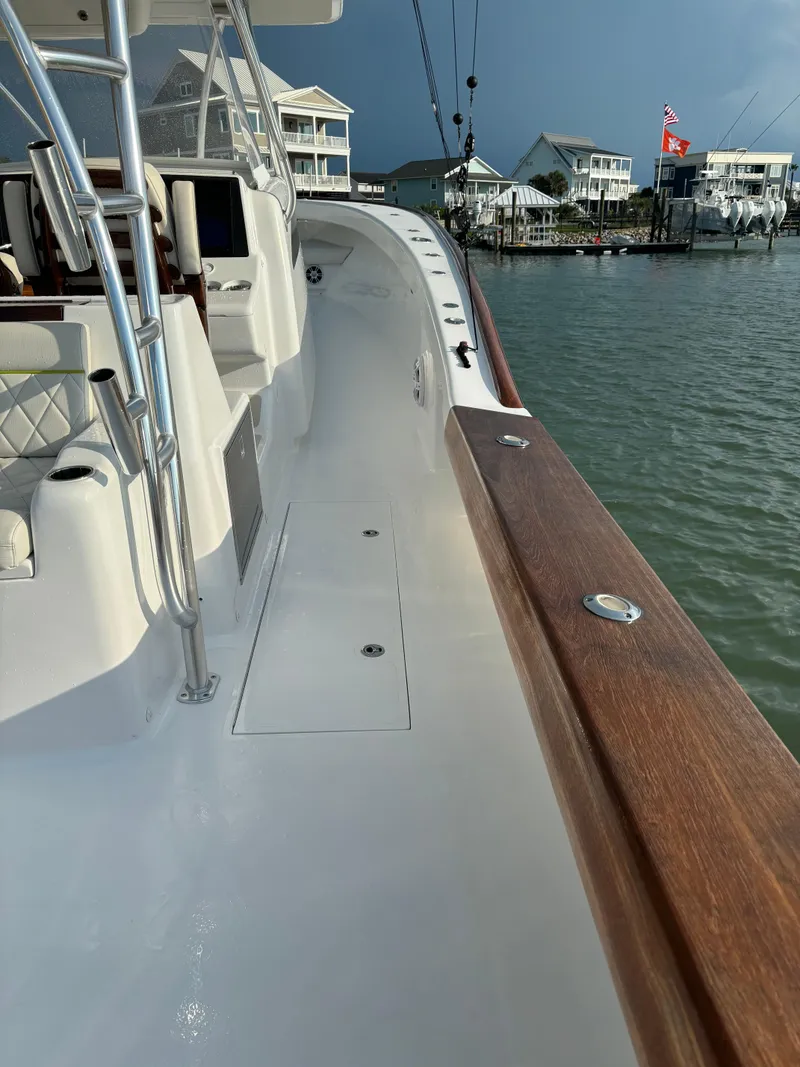 Slide: The Image of 2025 Mystique Boatworks M48 Custom Carolina docked near waterfront homes. - 15