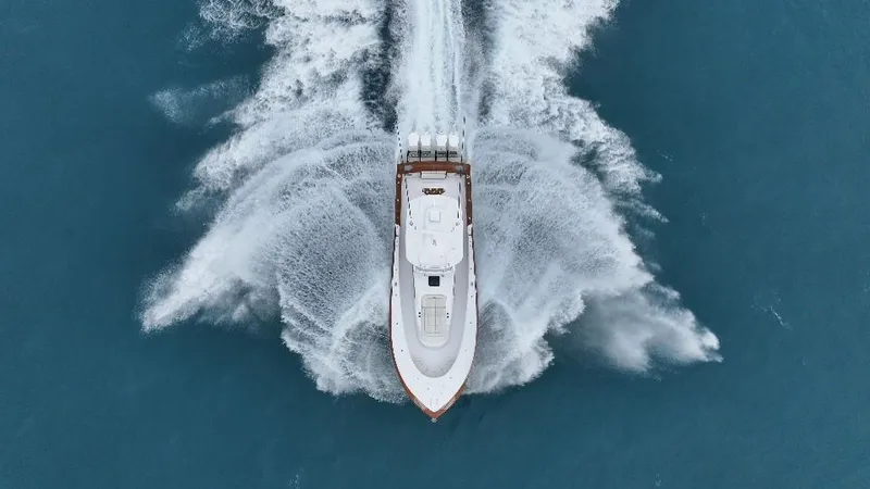 Slide: The Image of Aerial view of 2025 Mystique Boatworks M48 Custom Carolina speeding on blue water. - 7