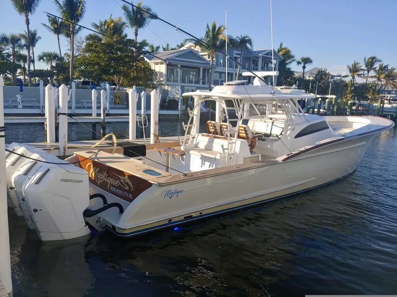 Slide: The Image of 2025 Mystique Boatworks M48 Custom Carolina docked by waterfront homes. - 9