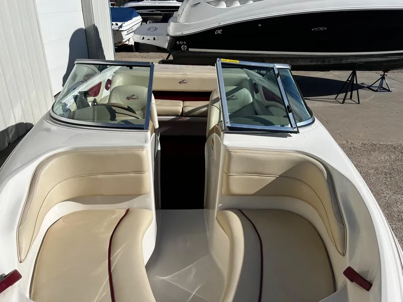 Slide: The Image of 2000 Sea Ray 185 Bow Rider interior with beige seating and open windshield. - 12