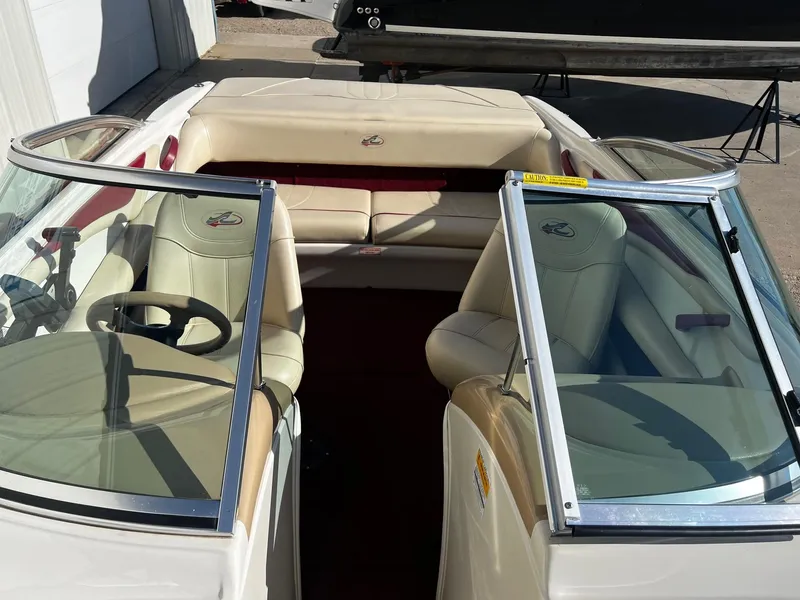 Slide: The Image of 2000 Sea Ray 185 Bow Rider interior with beige seats and open windshield. - 6