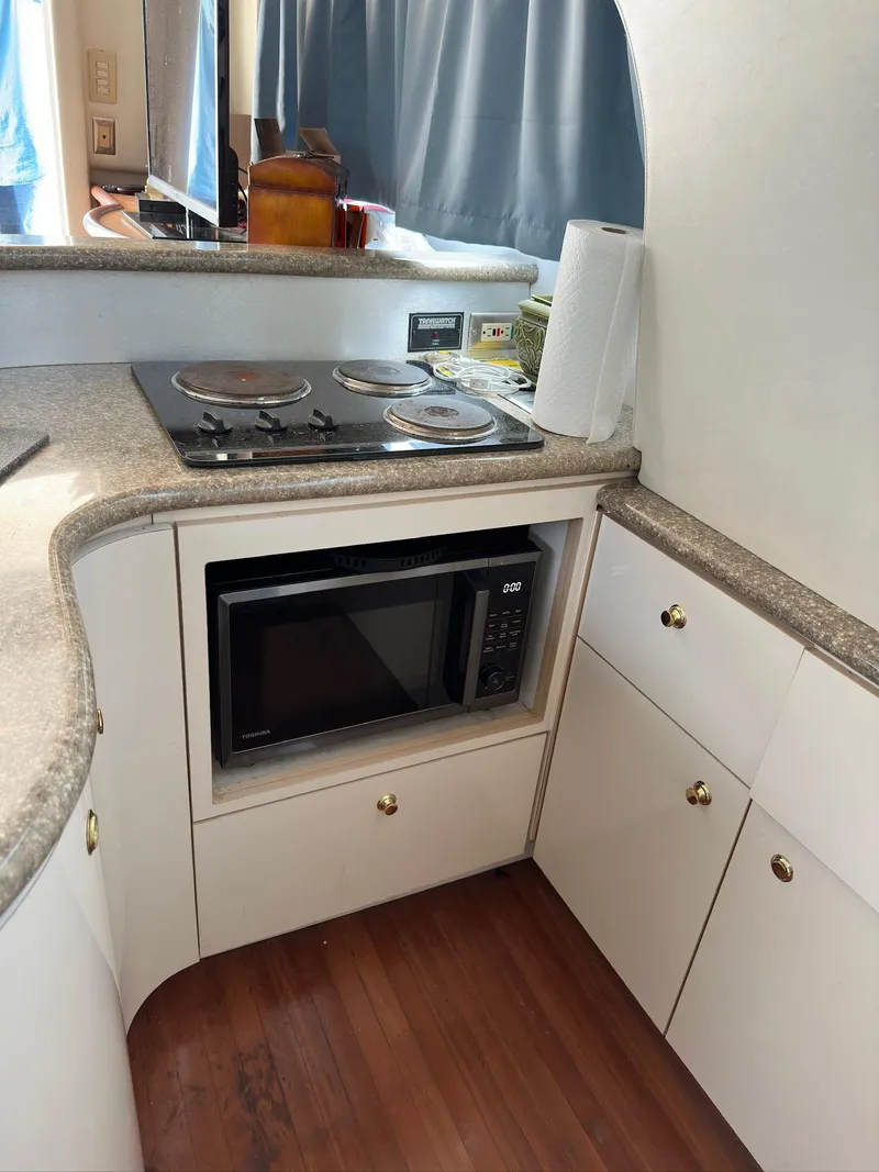 Slide: The Image of 1998 Maxum 4600 SCB yacht kitchen with stove, microwave, and cabinets. - 11