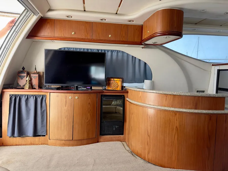 Slide: The Image of Interior of a 1998 Maxum 4600 SCB yacht with wood cabinetry and a flat-screen TV. - 12
