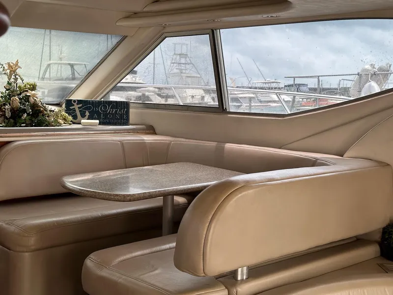 Slide: The Image of Interior of 1998 Maxum 4600 SCB yacht with beige seating and table, floral arrangement. - 17