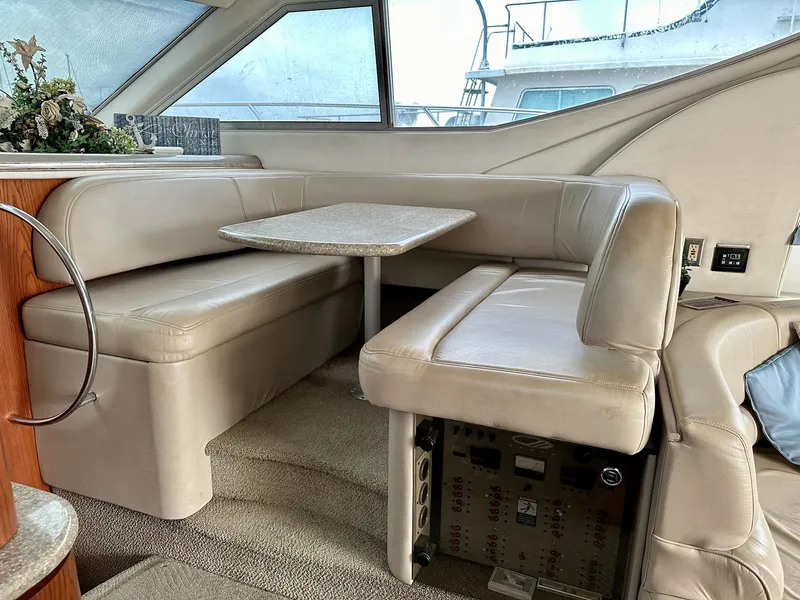 Slide: The Image of Interior of 1998 Maxum 4600 SCB yacht with beige leather seating and table. - 18