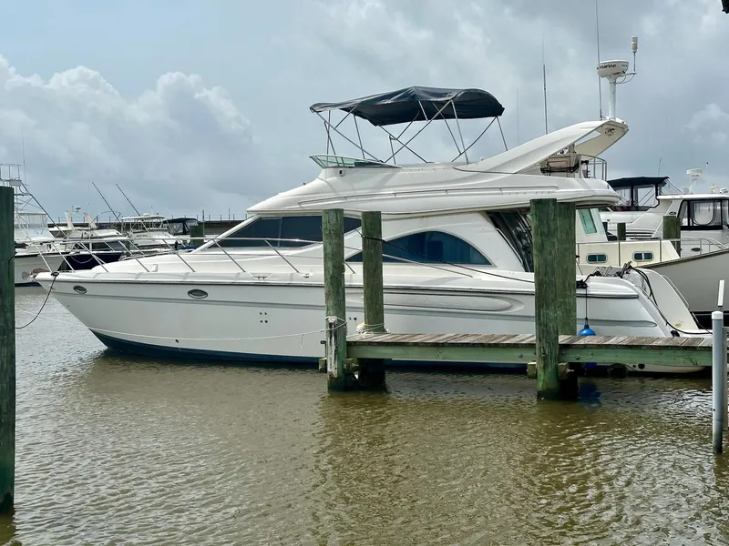 Slide: The Image of 1998 Maxum 4600 SCB yacht docked at marina under cloudy skies. - 2