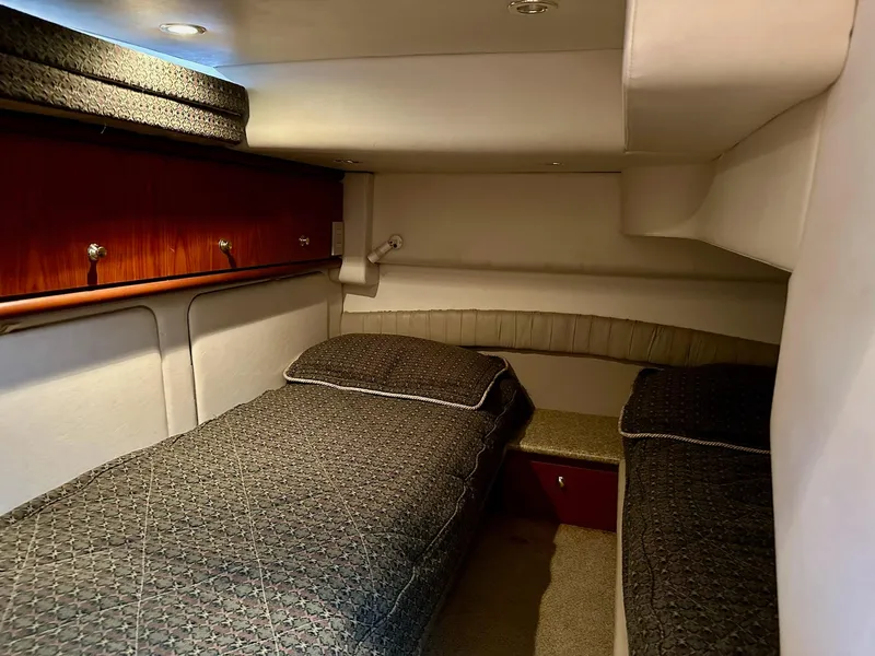 Slide: The Image of Interior cabin of 1998 Maxum 4600 SCB yacht with twin beds and wooden accents. - 21