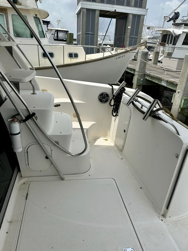 Slide: The Image of 1998 Maxum 4600 SCB yacht deck with steps and docked boats in background. - 5