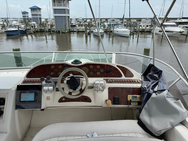 Slide: The Image of 1998 Maxum 4600 SCB yacht helm with marina view, featuring navigation controls and instruments. - 8