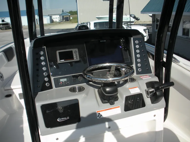 Slide: The Image of 2022 Robalo R230 Center Console boat dashboard with steering wheel and navigation controls. - 10