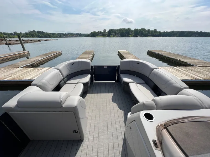Slide: The Image of 2024 Starcraft SLS 3 Q DH pontoon boat with spacious seating at a serene lake dock. - 2