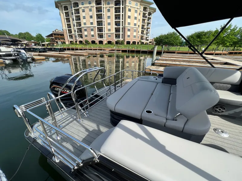 Slide: The Image of 2024 Starcraft SLS 3 Q DH pontoon boat docked at a marina with luxury seating. - 4