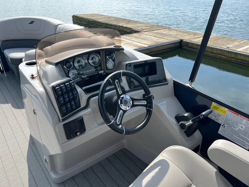 Slide: The Image of 2024 Starcraft SLS 3 Q DH boat helm with steering wheel and control panel. - 6
