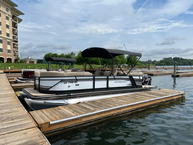 The Image of 2024 Starcraft SLS 3 pontoon boat docked at a marina. - 0