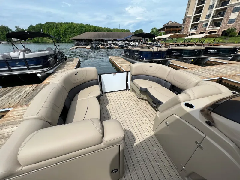 Slide: The Image of 2024 Starcraft SLS 3 pontoon boat with beige seating at a marina. - 5