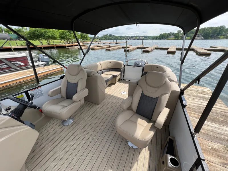 Slide: The Image of 2024 Starcraft SLS 3 pontoon boat interior with beige seating at a dock. - 7