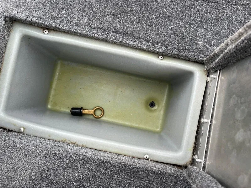 Slide: The Image of Storage compartment of a 2018 Tracker Pro Team 190 boat with a drain plug. - 40