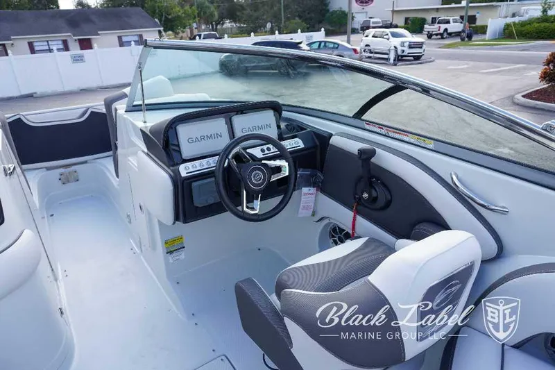 Slide: The Image of 2024 Crownline E240 XS boat interior with Garmin navigation system and steering wheel. - 14