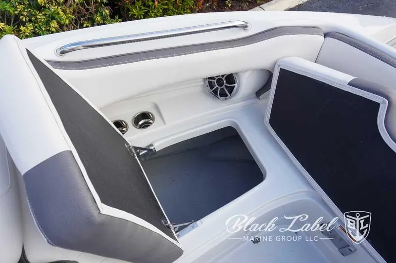 Slide: The Image of 2024 Crownline E240 XS boat interior storage compartment with speaker and cup holders. - 17