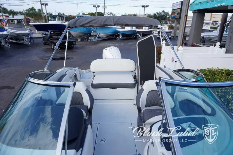 Slide: The Image of 2024 Crownline E240 XS boat interior with seating and windshield, displayed at Black Label Marine Group. - 19