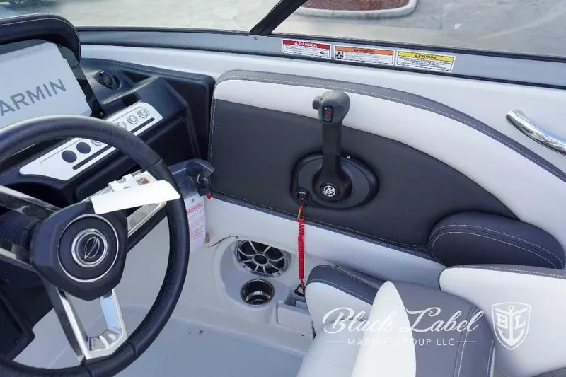 Slide: The Image of 2024 Crownline E240 XS boat cockpit with Garmin navigation system and Black Label Marine Group logo. - 24
