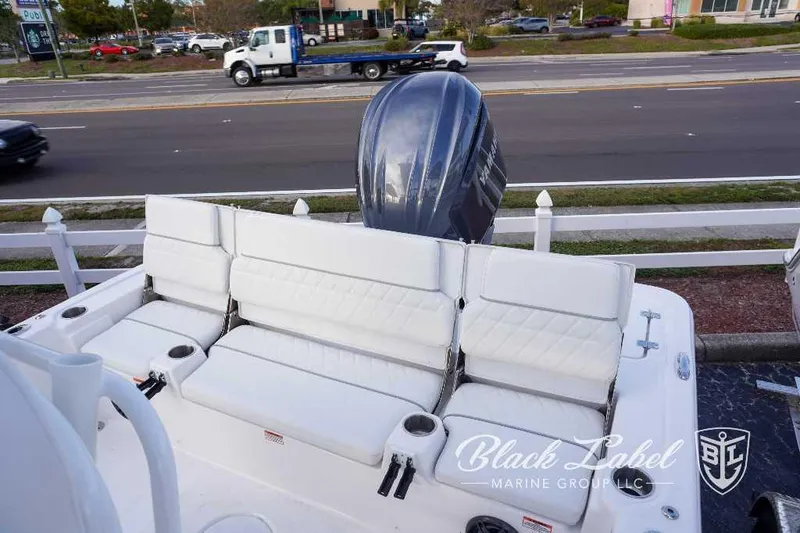 Slide: The Image of 2024 Sea Fox 251 Bay boat with white cushioned seating and outboard motor. - 9