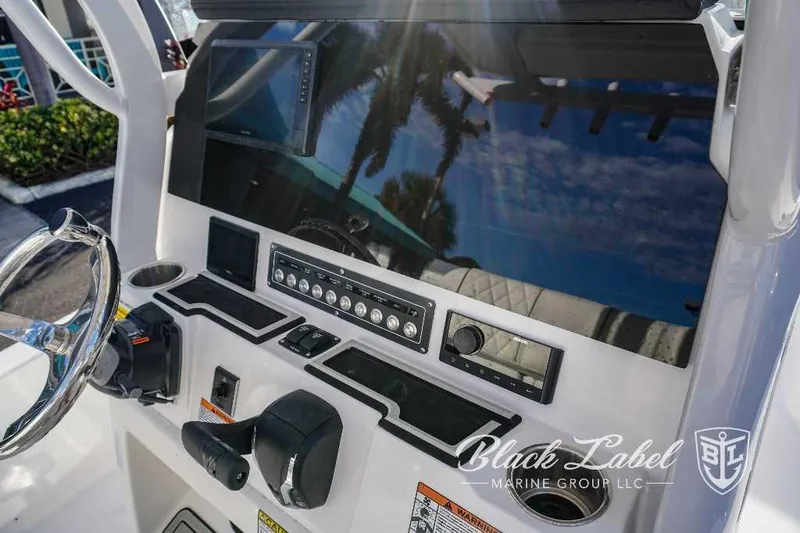 Slide: The Image of 2024 Sea Fox Seafox 251 Bay boat dashboard with steering wheel and control panel. - 23