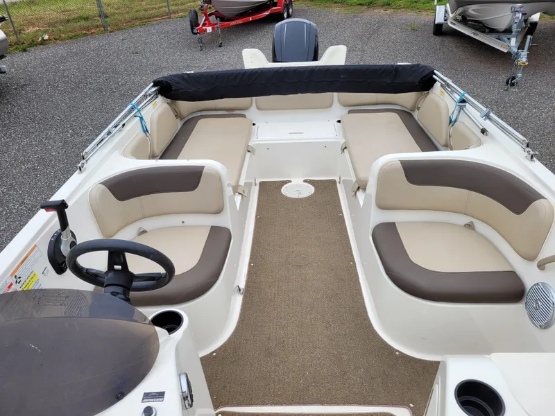 Slide: The Image of 2017 Bayliner Element E21 boat interior with beige and brown seating. - 11