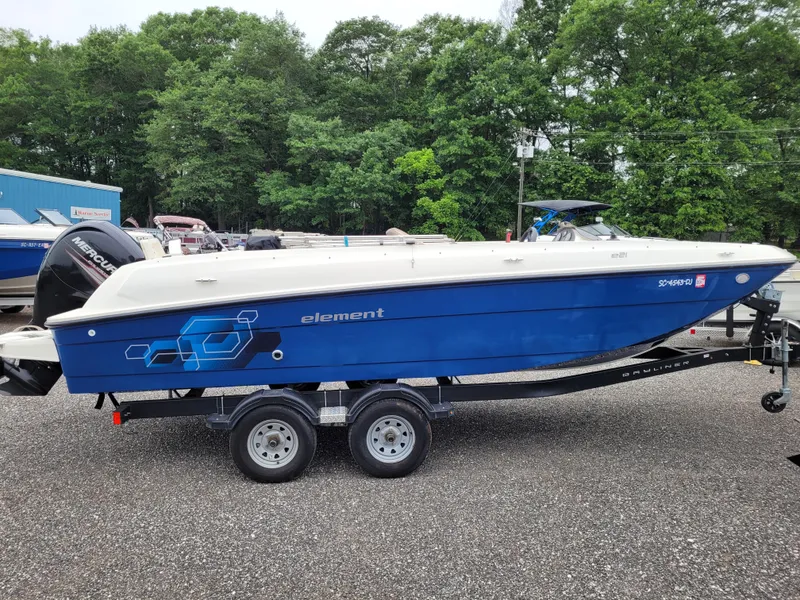 Slide: The Image of 2017 Bayliner Element E21 boat on a trailer, blue hull, parked outdoors. - 4
