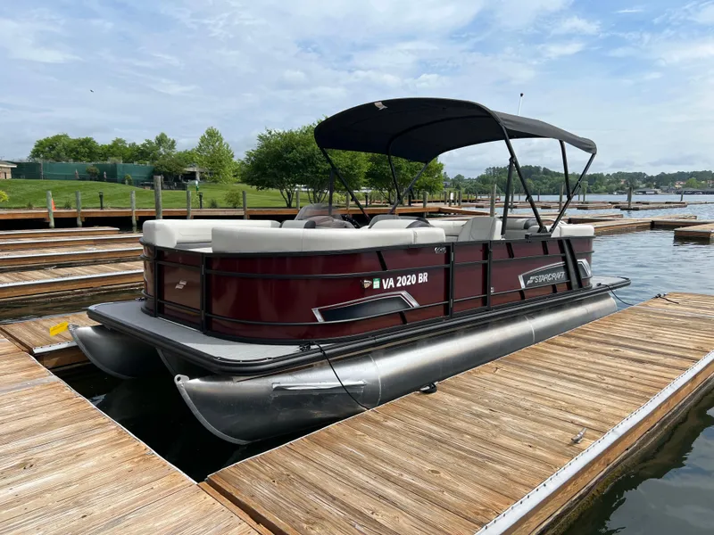 The Image of 2024 Starcraft EXS 3 pontoon boat docked at a marina. - 0