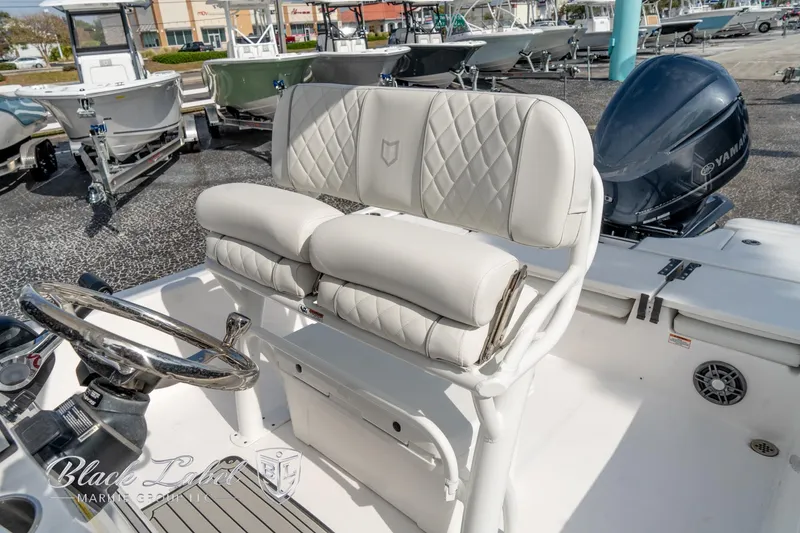 Slide: The Image of 2024 Sea Fox Seafox 251 Bay boat interior with cushioned seating and steering wheel. - 21