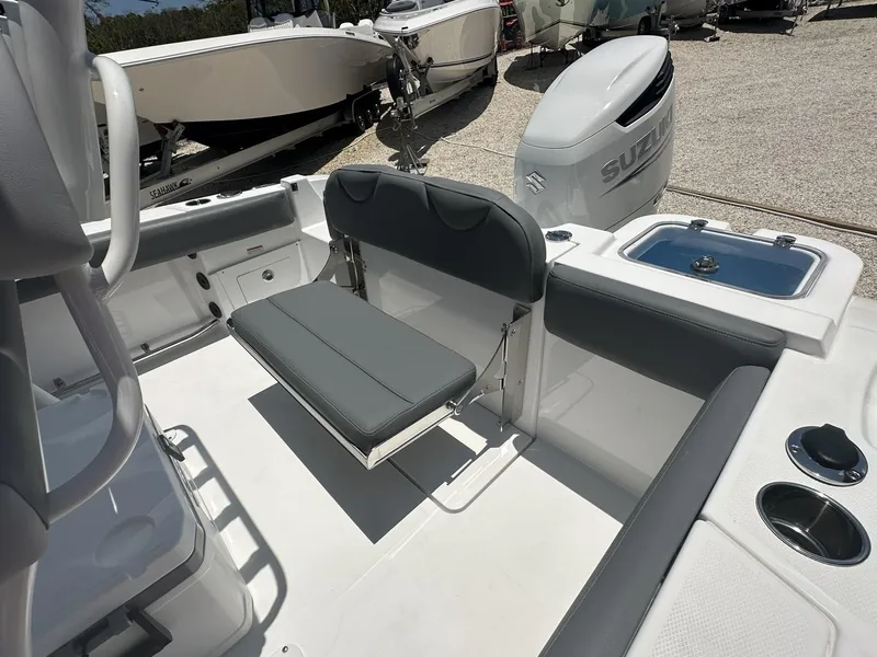 Slide: The Image of 2024 NauticStar 222 OS boat interior with seating and Suzuki outboard motor. - 18