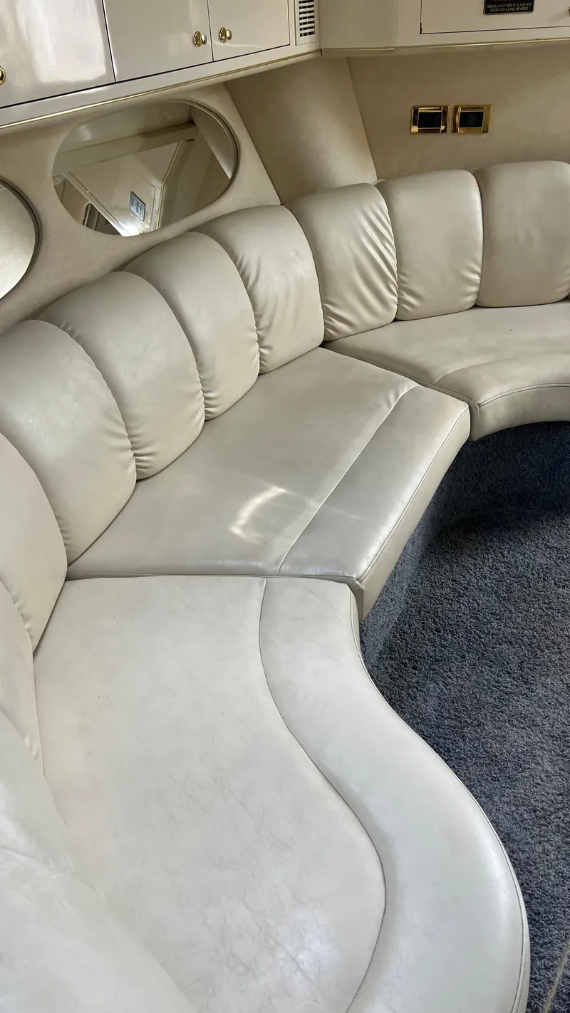 Slide: The Image of Interior of 1997 Sea Ray 400 yacht with curved white leather seating and carpeted floor. - 25