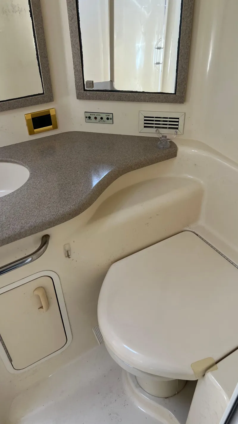 Slide: The Image of Bathroom of a 1997 Sea Ray 400 yacht with sink, toilet, and mirror. - 26