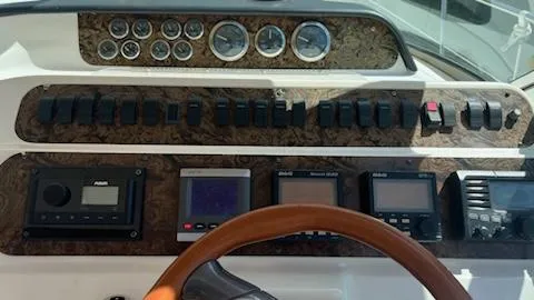 Slide: The Image of 1997 Sea Ray 400 boat dashboard with gauges, switches, and navigation equipment. - 7