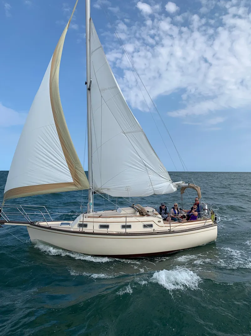 Slide: The Image of 1986 Island Packet 27 Sloop sailing on open sea under clear blue sky. - 1