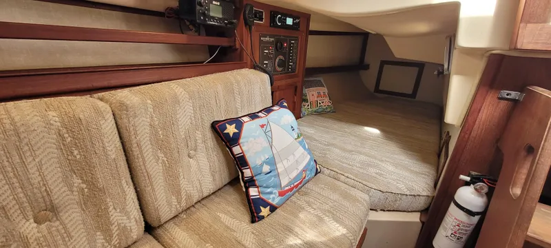 Slide: The Image of Interior of 1986 Island Packet 27 Sloop with cozy seating and nautical-themed decor. - 11