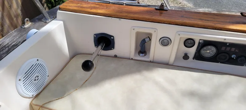 Slide: The Image of 1986 Island Packet 27 Sloop cockpit controls with wooden trim and navigation instruments. - 29