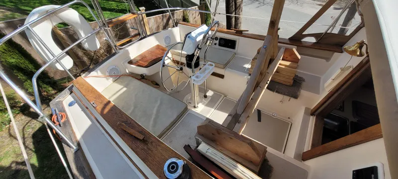 Slide: The Image of 1986 Island Packet 27 Sloop cockpit with wooden accents and steering wheel. - 47