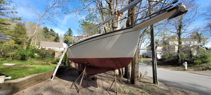 Slide: The Image of 1986 Island Packet 27 Sloop sailboat on stands in a residential area. - 49