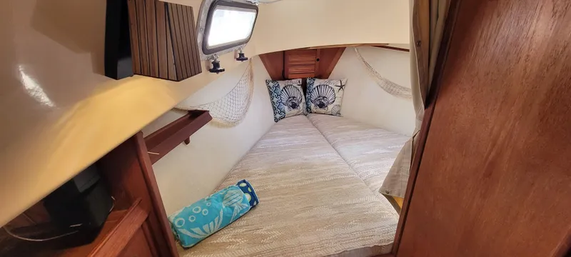 Slide: The Image of Cozy cabin interior of 1986 Island Packet 27 Sloop with cushions and porthole. - 9