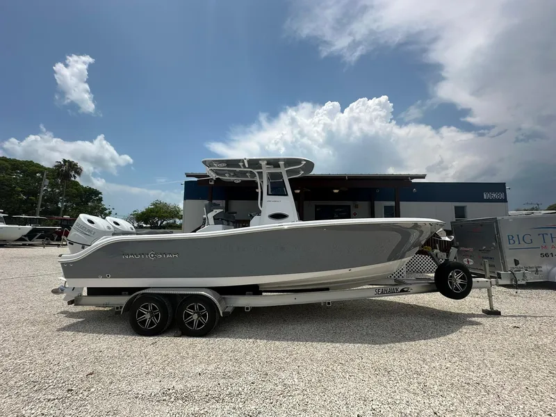 Slide: The Image of 2024 NauticStar 252 boat on a trailer in a dealership lot. - 0